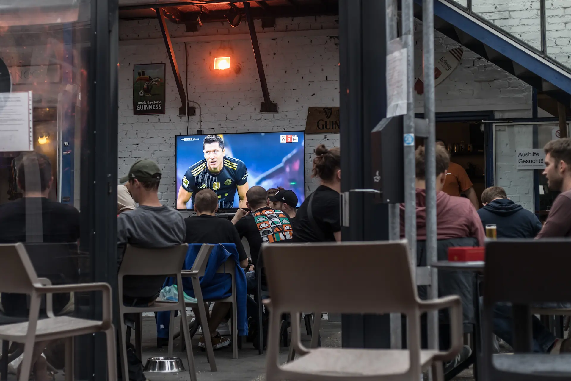 Gäste schauen Fußball auf der Terrasse der Bar Sowiso Ocean in Aachen